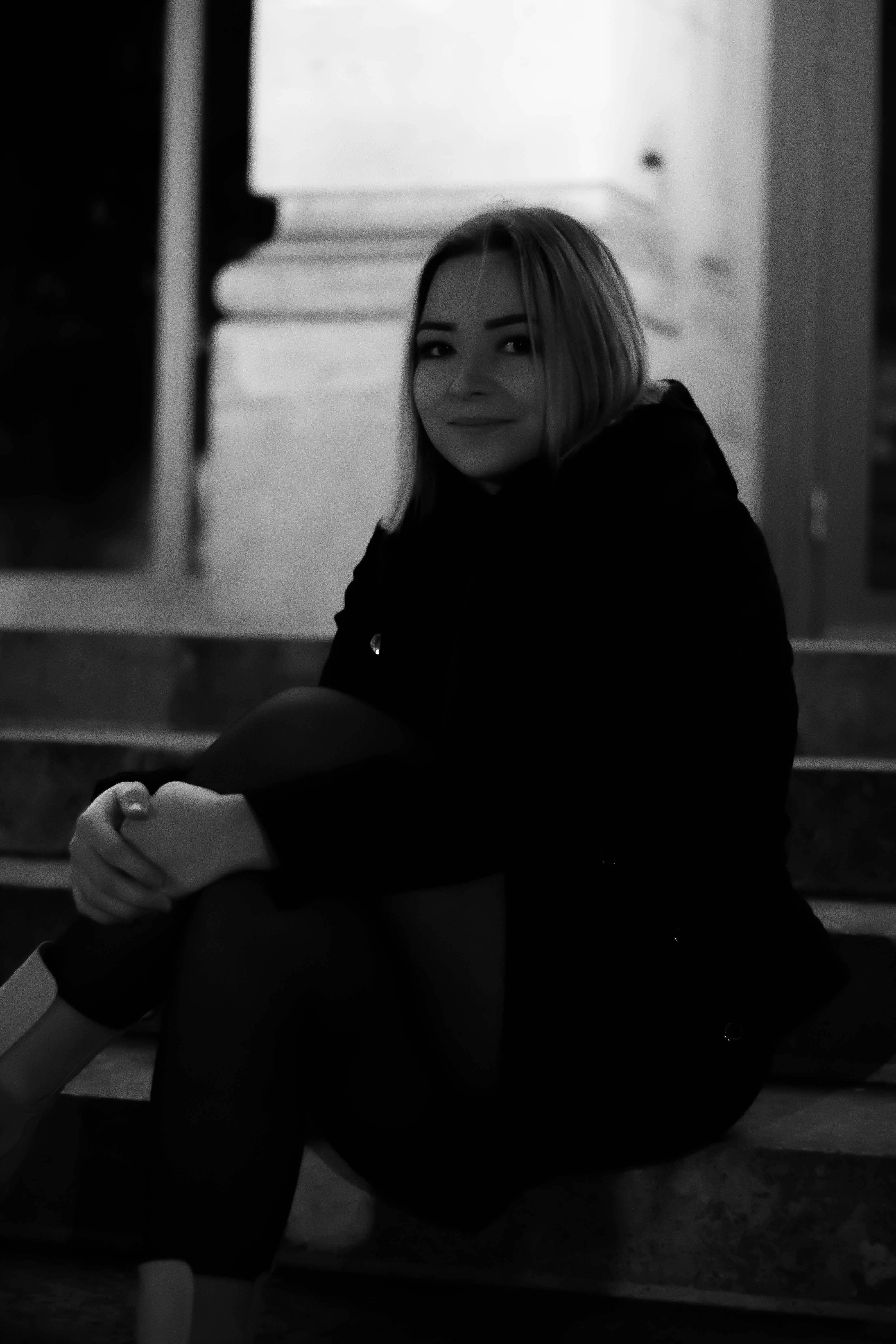Photo d'une jeune femme assise sur un escalier avec les jambes croisés